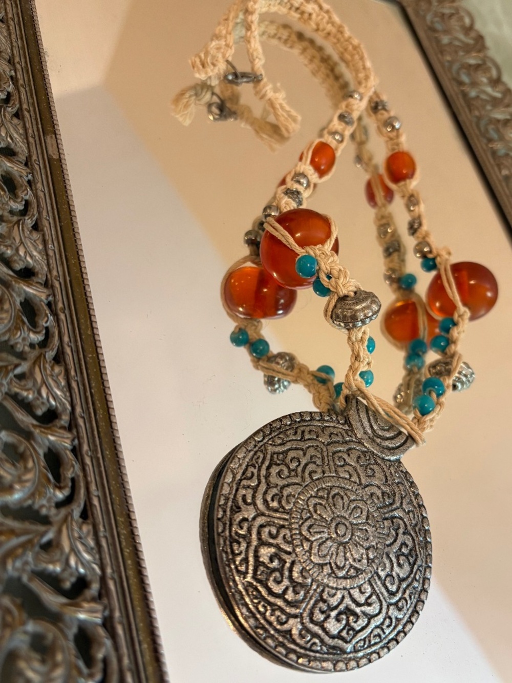 Handmade hemp necklace with large silver emblem, orange glass beads